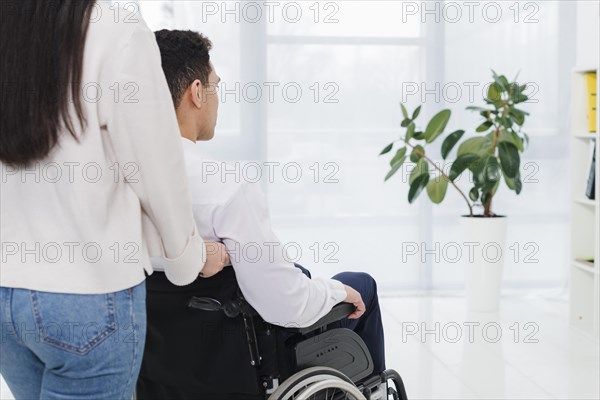 Close up man pushing woman wheelchair