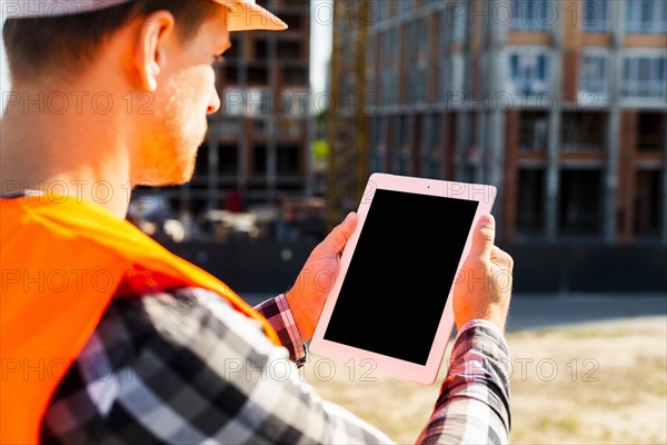 Close up side view construction engineer using tablet