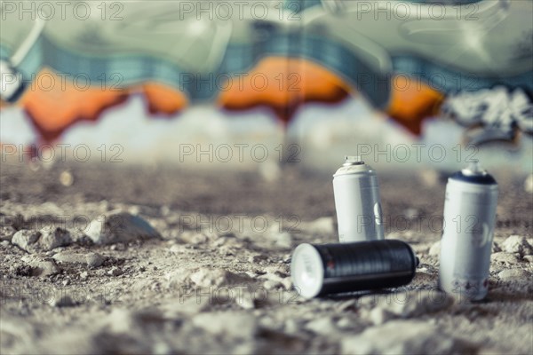 Close up spray cans front graffiti wall