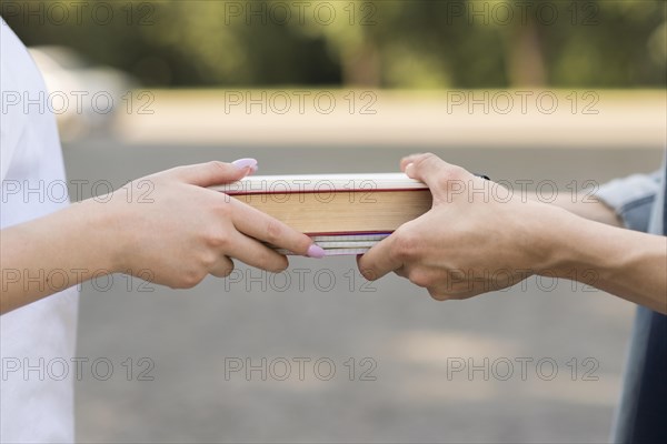 Close up students exchanging book