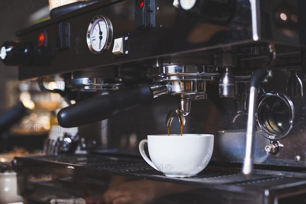 Coffee machine pours freshly coffee white cup