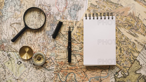 Compass magnifying glass near notebook pen