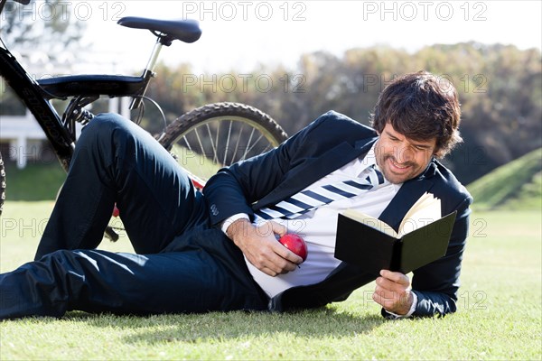 Concentrated worker reading book grass