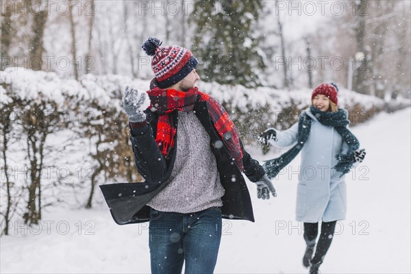 Content couple playing snowballs park