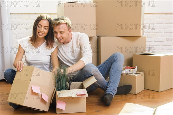 Couple sitting floor inspect box