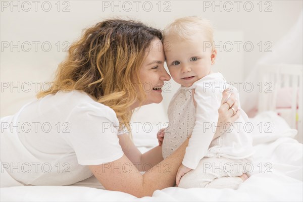 Cute baby girl playing with mother home