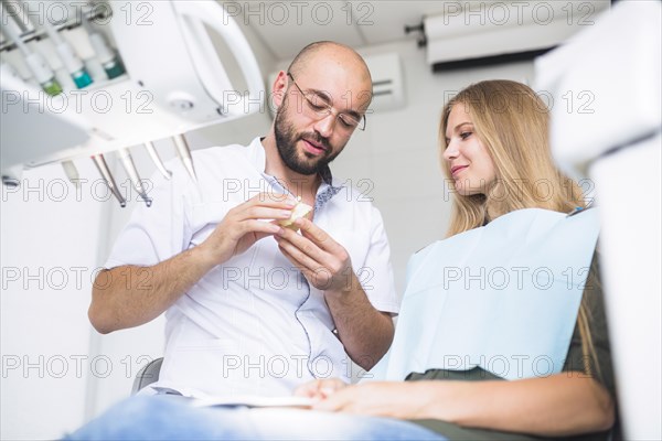 Dentist explaining dental hygiene female patient