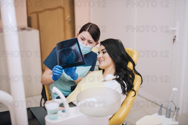 Dentist showing teeth x ray patient