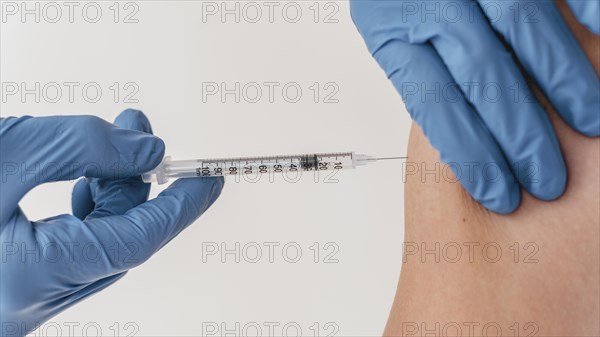 Doctor with gloves administering vaccine patient