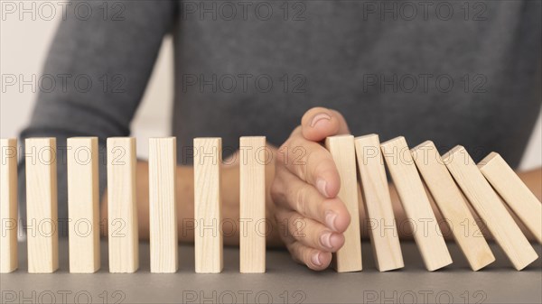 Domino made with wooden pieces representing finances struggles