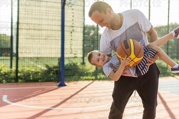 Father son playing basketball field