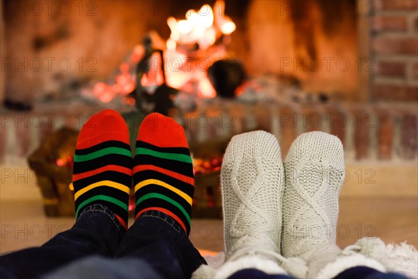 Feet christmas socks near fireplace