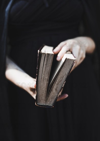 Female black dress holding ancient book