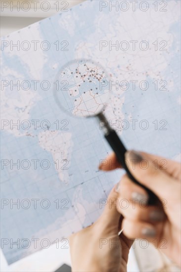 Female tourist searching places travel map through magnifying glass