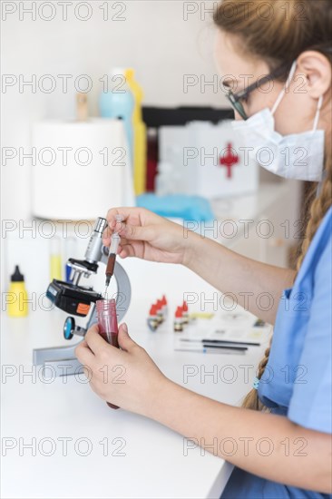 Female veterinarian examining blood sample clinic