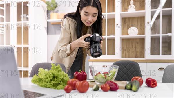 Female vlogger home taking pictures with camera