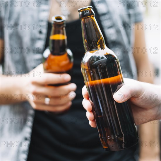 Friends holding bottle beer