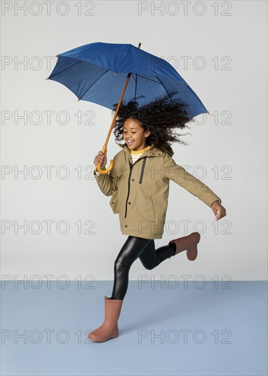 Full shot girl running with umbrella