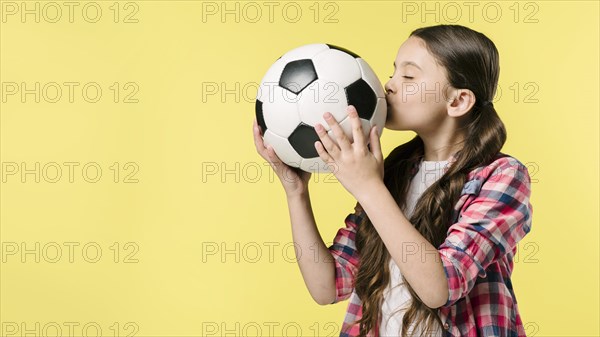 Girl kissing football studio