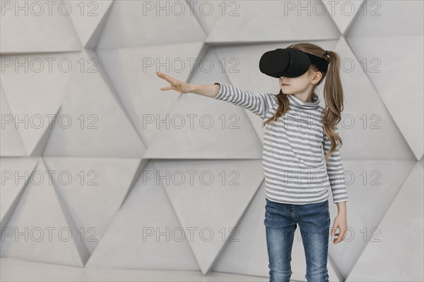Girl wearing virtual reality headset stretching her hand