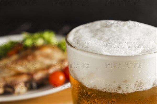 Glass beer with defocused steak