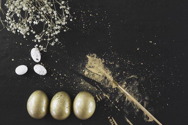 Golden eggs near flowers