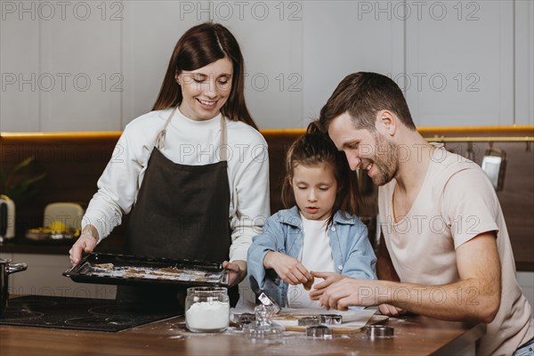 Happy family father mother with daughter cooking together