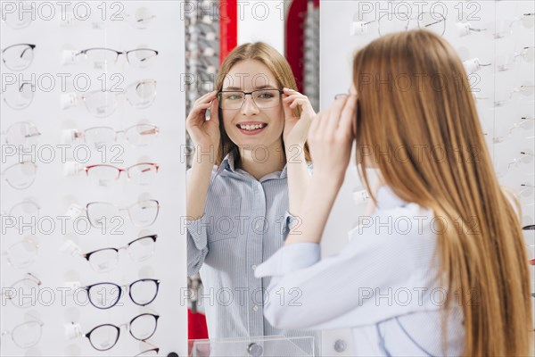 Happy woman looking new glasses optometrist