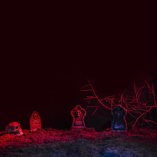 Headstones skull illuminated by red light ground