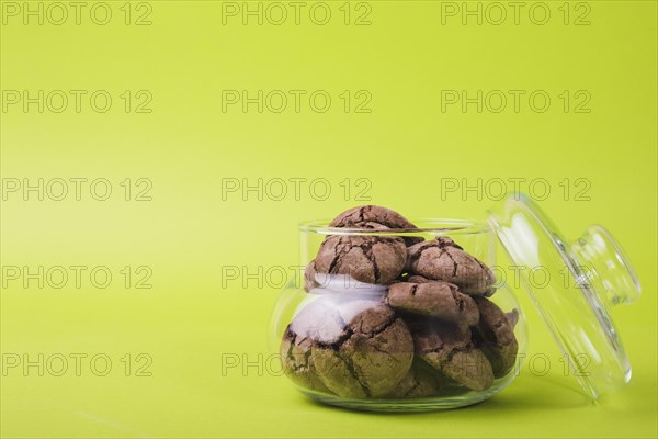 Homemade baked chocolate cookies glass jar green background