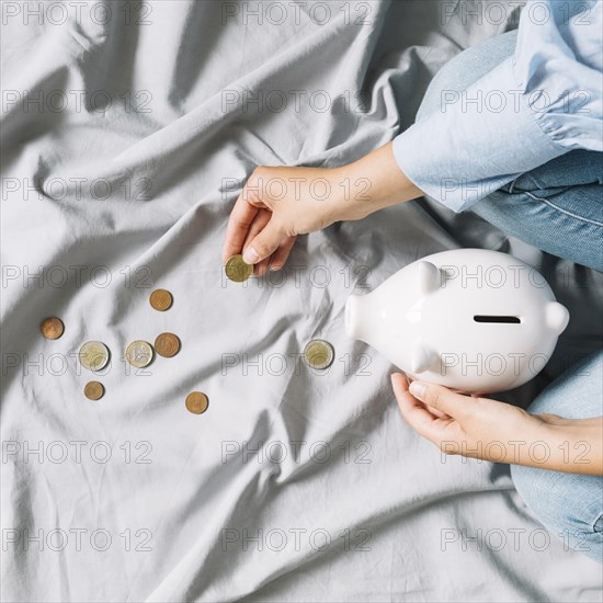 Human hand holding coins piggybank