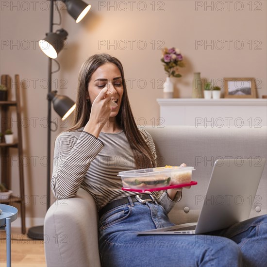 Hungry businesswoman eating sitting sofa