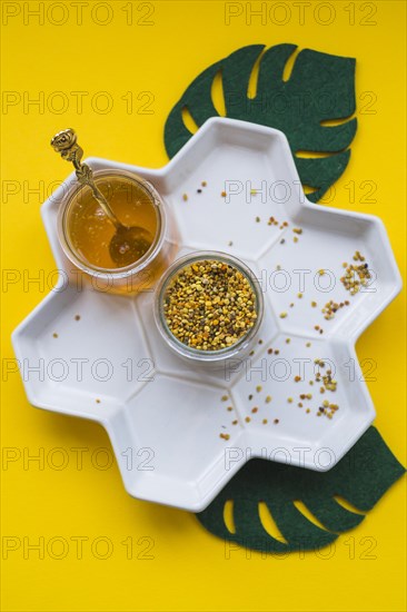 Jar bee pollens honey white tray yellow background