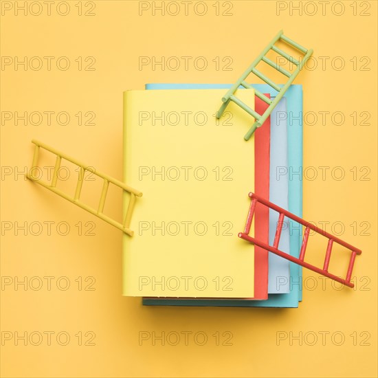 Ladders leaning stack colorful books