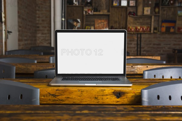 Laptop with white display screen wooden table caf