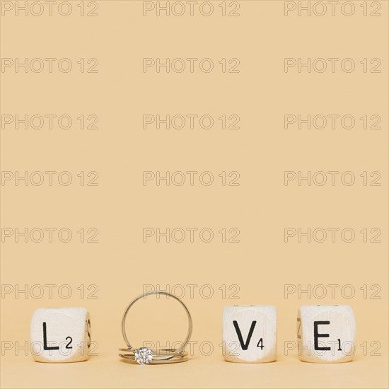 Love letter made with wedding diamond rings cubes cream background