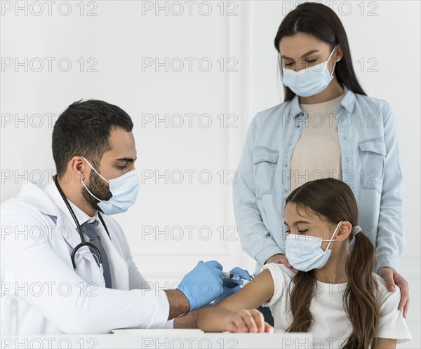 Male doctor vaccinating little girl