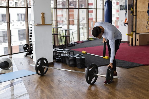 Man placing weight plates bar