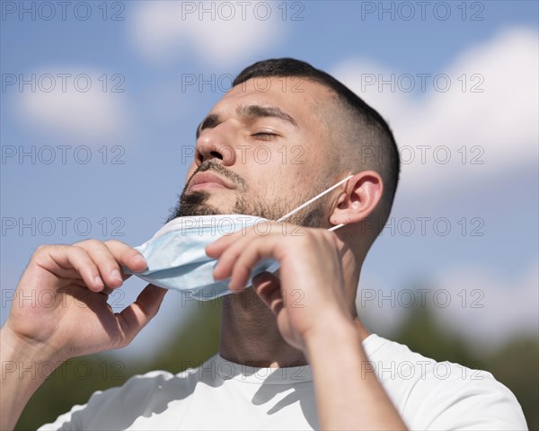 Man taking off his medical mask