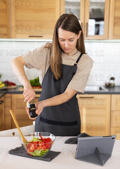 Medium shot woman spicing food