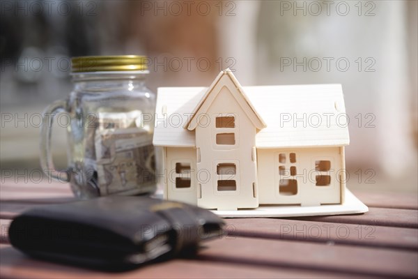 Miniature house with savings jar wallet