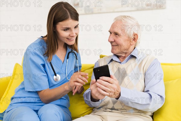 Old man showing s phone nurse