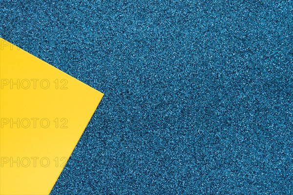 Overhead view yellow cardboard paper blue surface