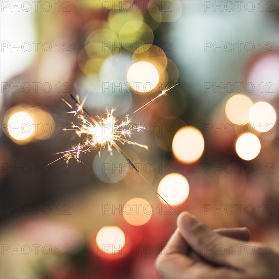 Person holding burning bengal fire blurred background