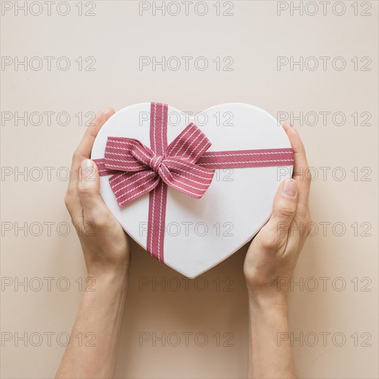 Person holding gift box heart shape