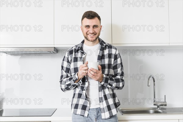 Portrait smiling young man holding cup hand looking camera