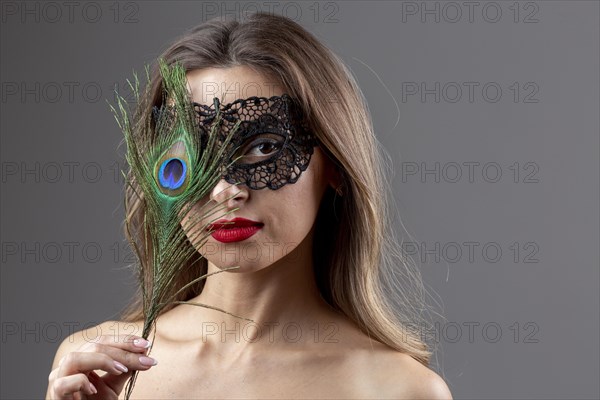 Portrait young woman with peacock feather