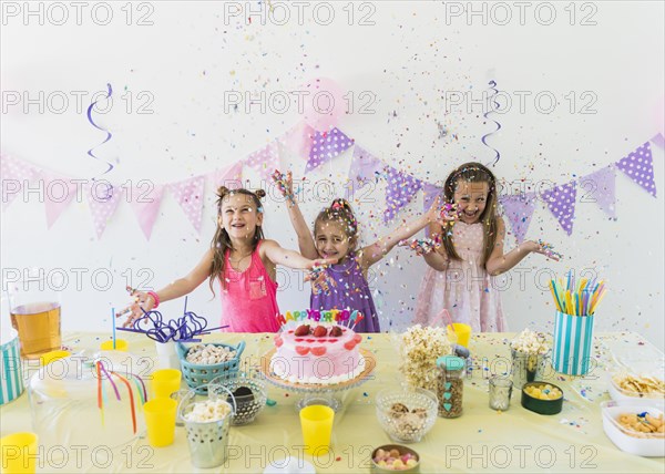 Pretty girls enjoying birthday party home with variety food juice table