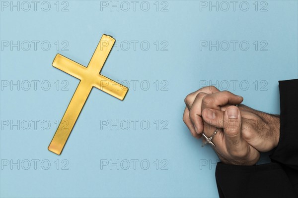 Priest praying with wood cross