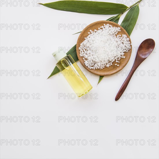 Rock salt leaves spoon essential oil spray bottle white background